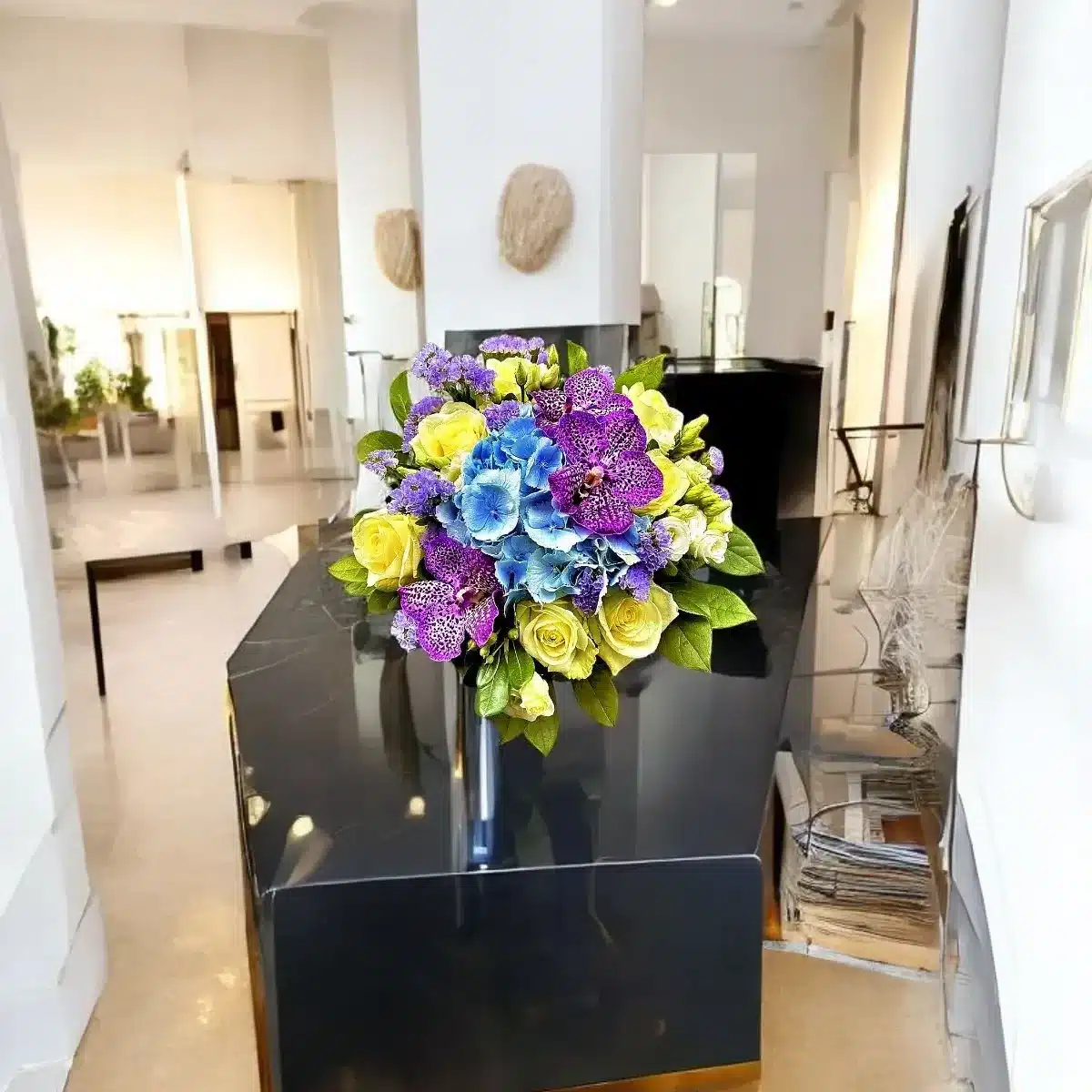 bouquet orchidée Genève — orchidées mauves, hortensias bleus et roses crème, composition pastel élégante