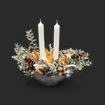 songe d'écorce : couronne de sapin, eucalyptus et oranges sèches autour de deux bougies ivoire dans un bol noir - centre de table