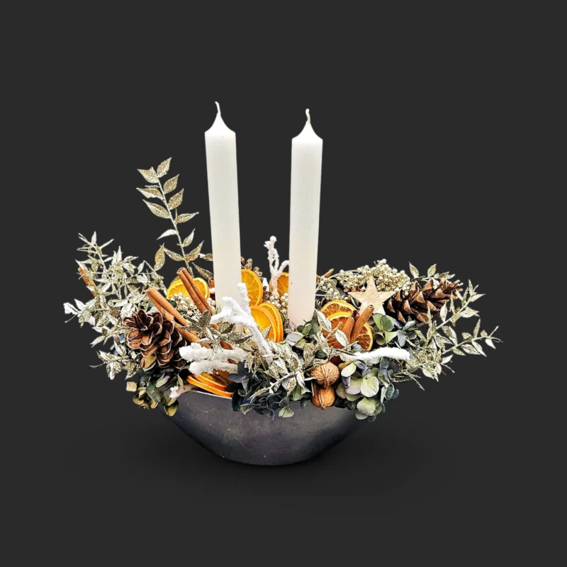 songe d'écorce : couronne de sapin, eucalyptus et oranges sèches autour de deux bougies ivoire dans un bol noir - centre de table