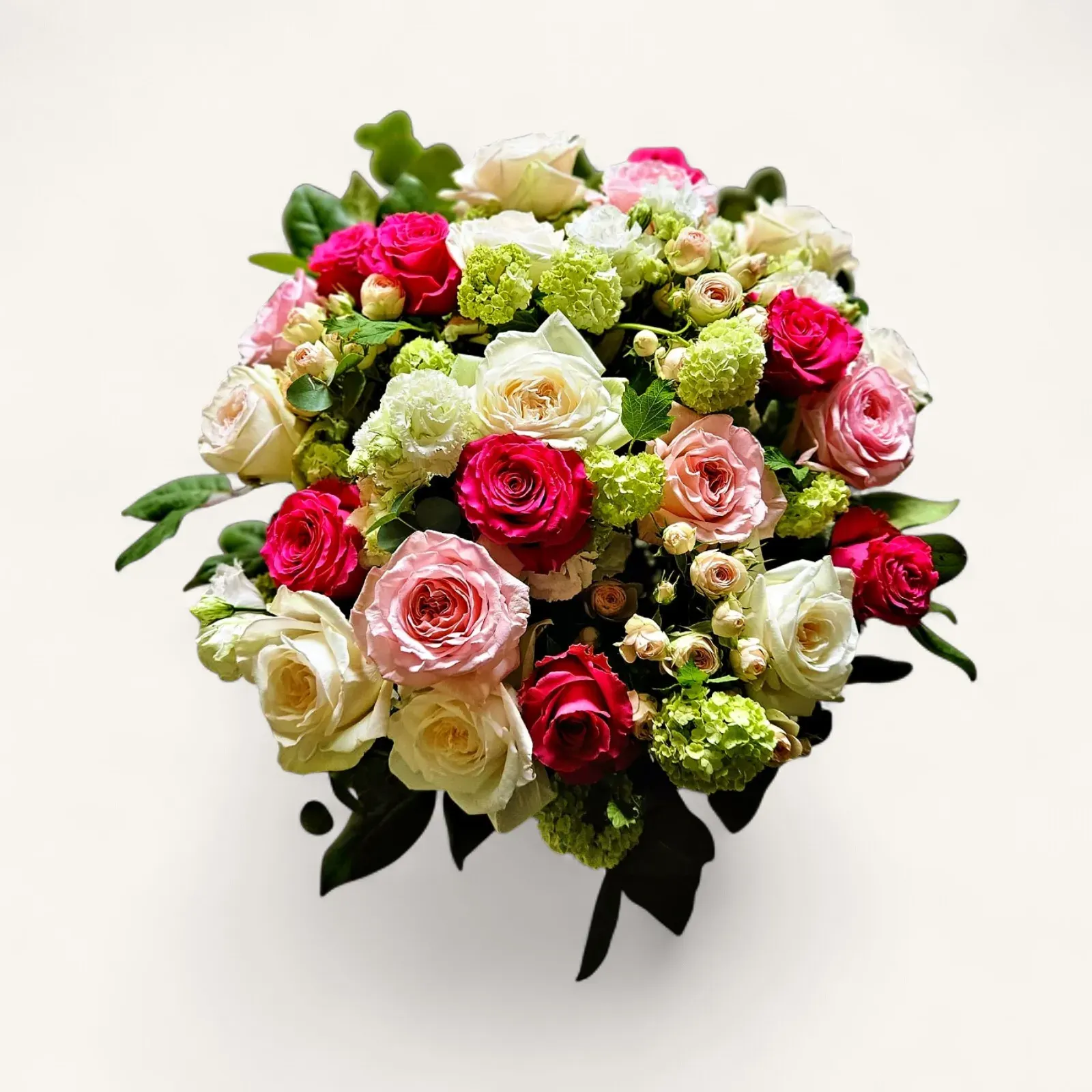 JTNE-44.webp bouquet roses Genève : roses rouges, roses et blanches avec feuillage vert, composition élégante et romantique