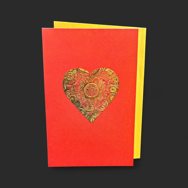 Notre carte de vœux Saint-Valentin Genève Brin d'Oraison, avec son cœur floral doré embossé sur fond rouge profond et son enveloppe or.