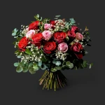 Le bouquet roses rouges roses genève « Passionnément » avec son feuillage d'eucalyptus et gypsophile sur fond noir.