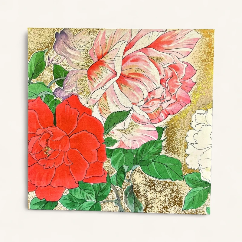 Gros plan sur une carte de vœux florale genève de luxe avec pivoines roses, camélias rouges et détails dorés.