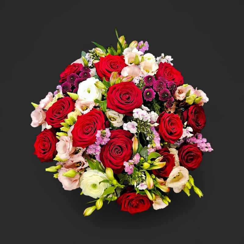 Le bouquet romantique genève, un arrangement de roses rouges éclatantes, lisianthus roses et touches mauves sur fond noir.