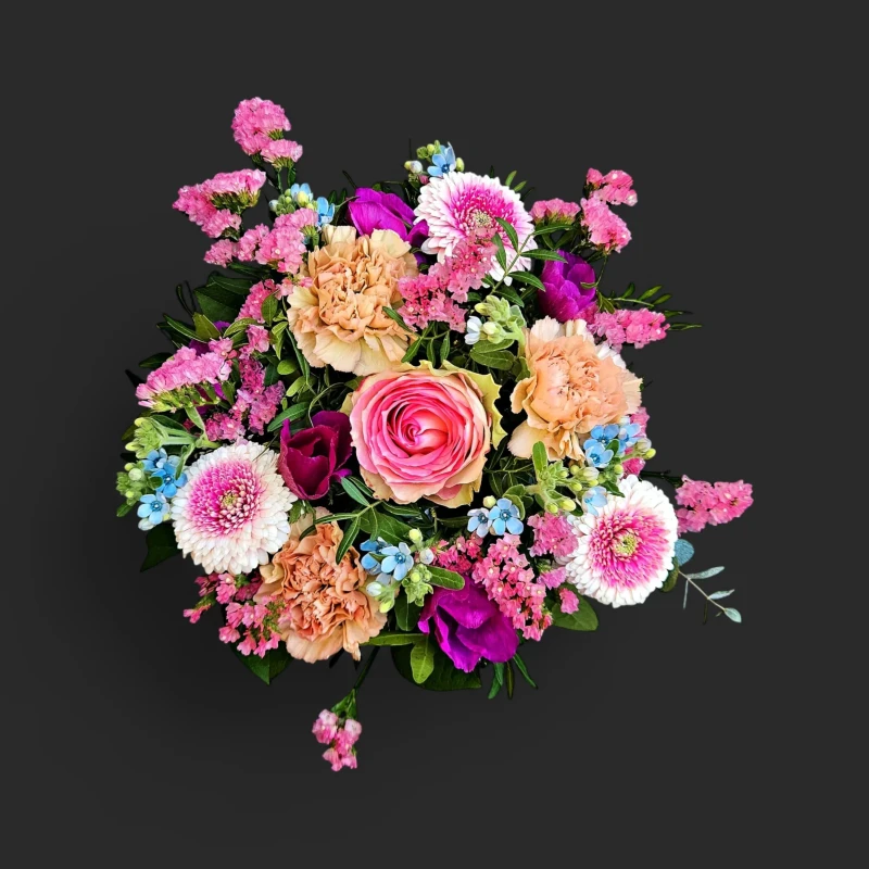 Gros plan du Rosée du Portique, notre bouquet printemps Genève, avec sa rose praline, ses œillets pêche et ses myosotis bleus.
