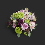 Vue rapprochée du bouquet viorne lilas orchidées genève 'Valse de Viorne' avec ses teintes pastel, hortensias verts et orchidées blanches.
