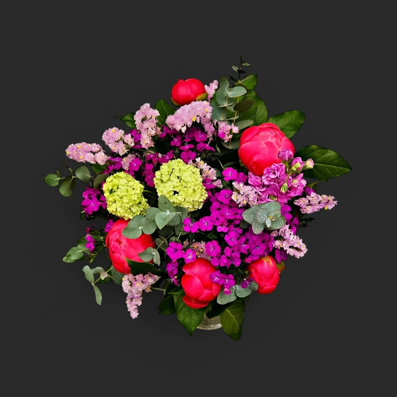 Gros plan du bouquet pivoines fête des mères genève "Vermeille d'Atelier" avec pivoines corail et fleurs colorées sur fond noir.