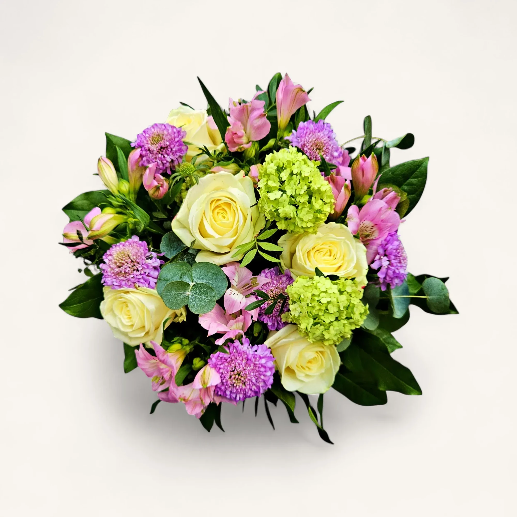RA-11.webp Gros plan du bouquet roses ivoire hortensia genève, composition pastel avec pompons violets et alstroemères roses sur fond noir.