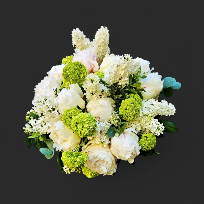 Gros plan du bouquet pivoines blanches lilas genève, un dôme harmonieux de fleurs blanches et touches de vert chartreux.