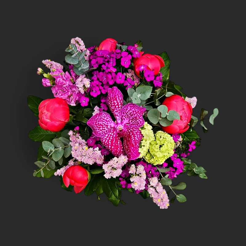 Gros plan du bouquet pivoines orchidées Genève Palimpseste Pourpre avec son orchidée vanda tachetée et ses pivoines corail.