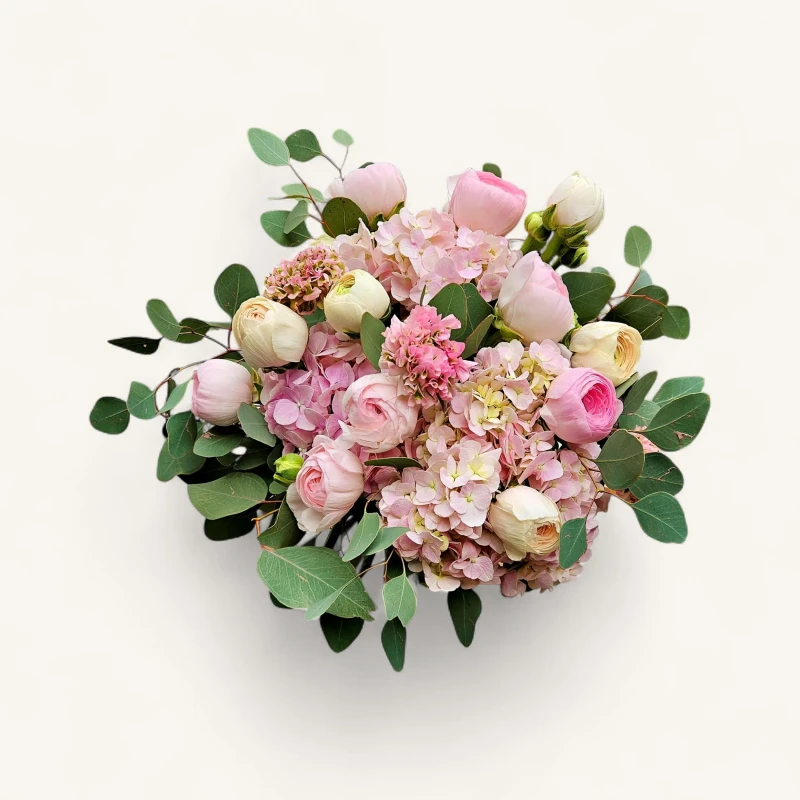 Vue de face du bouquet printemps hortensia geneve 'Brume de Printemps' avec ses renoncules, pivoines et eucalyptus pastel.