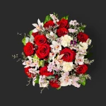 Luxueux bouquet roses rouges geneve 'Rubis de Mai' avec orchidées cymbidium blanches et œillets sur un fond noir contrastant.