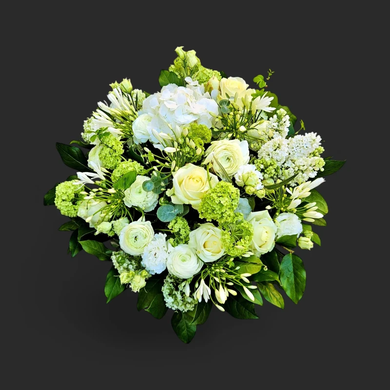 Gros plan sur le Vertige d'Ivoire, un luxuriant bouquet roses blanches hortensias genève avec des renoncules sur fond noir.