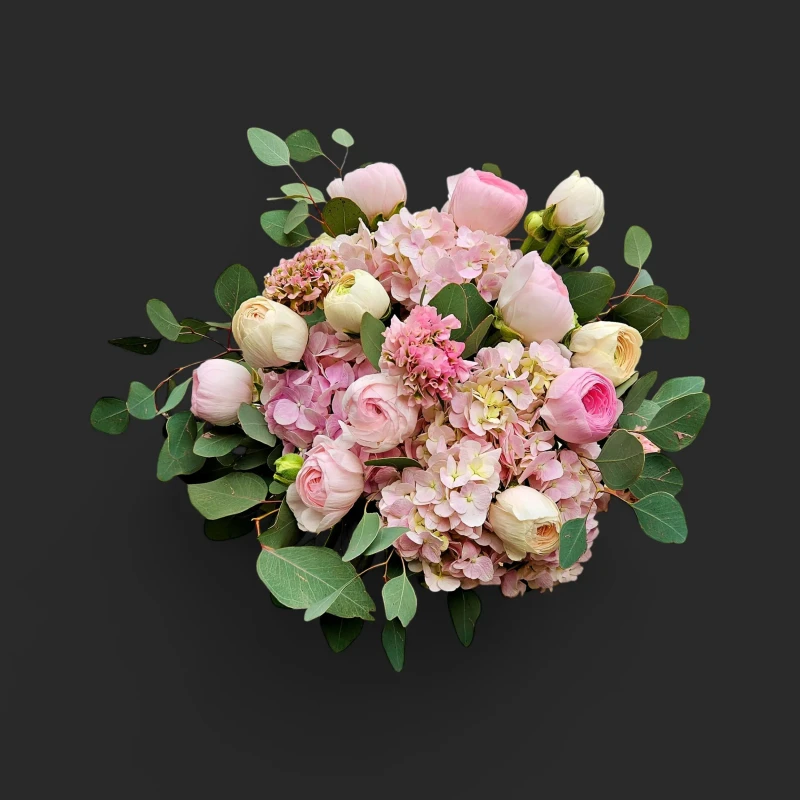 Vue de face du bouquet printemps hortensia geneve 'Brume de Printemps' avec ses renoncules, pivoines et eucalyptus pastel.