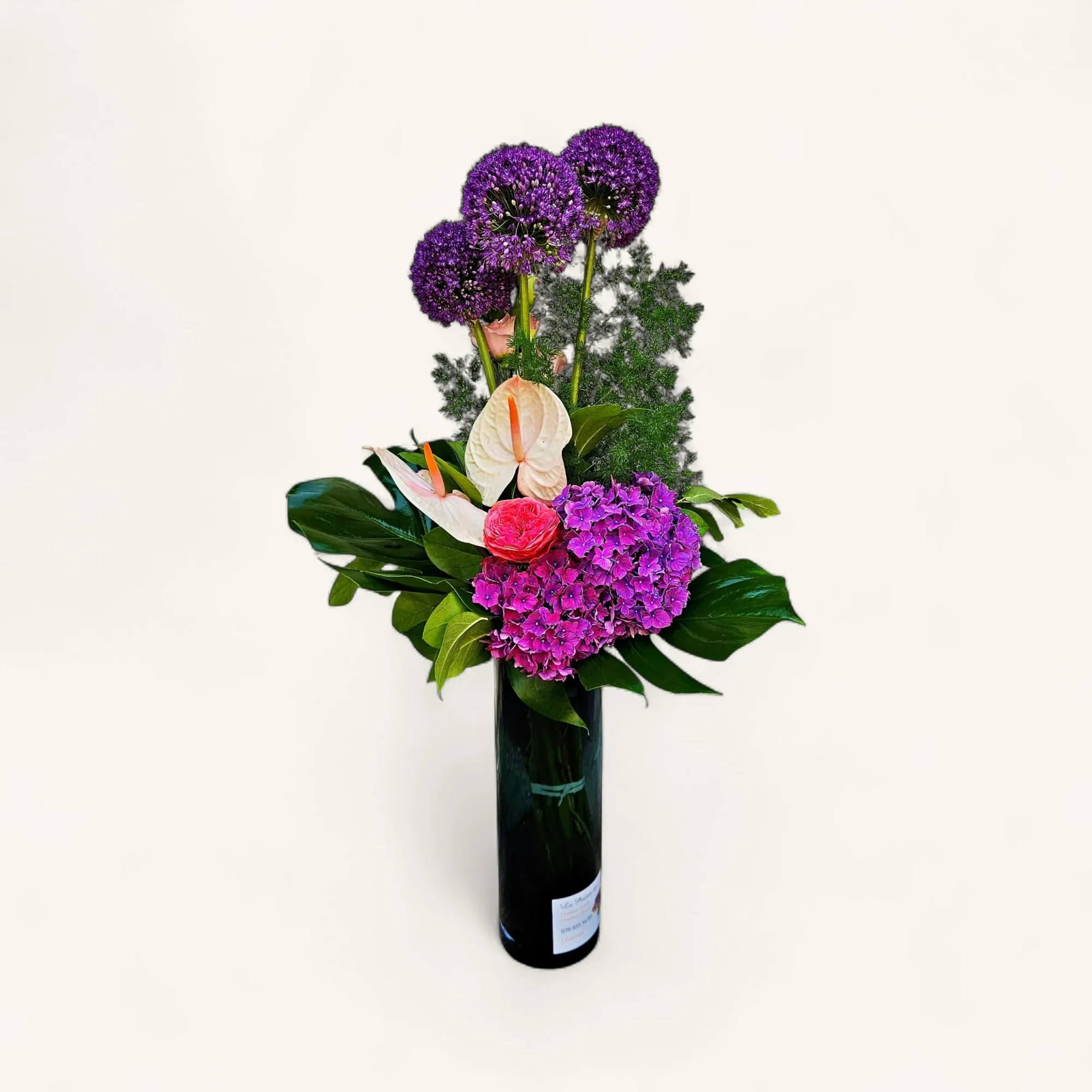 RkElM0Q.webp Notre bouquet moderne violet genève avec des globes d'allium, une rose fuchsia, des anthuriums ivoire et un hortensia pourpre.