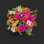 Gros plan sur le Cantique de Sienne, un dense bouquet fleurs colorées genève avec roses fuchsia, dahlias et fleurs d'été.