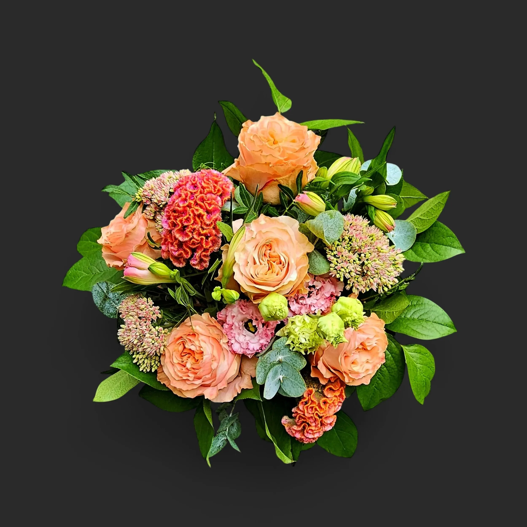 QlQ0JTNE.webp Gros plan sur le bouquet roses pêche genève 'Carnet de Septembre', une harmonie pastel de roses, célosie et sedum.