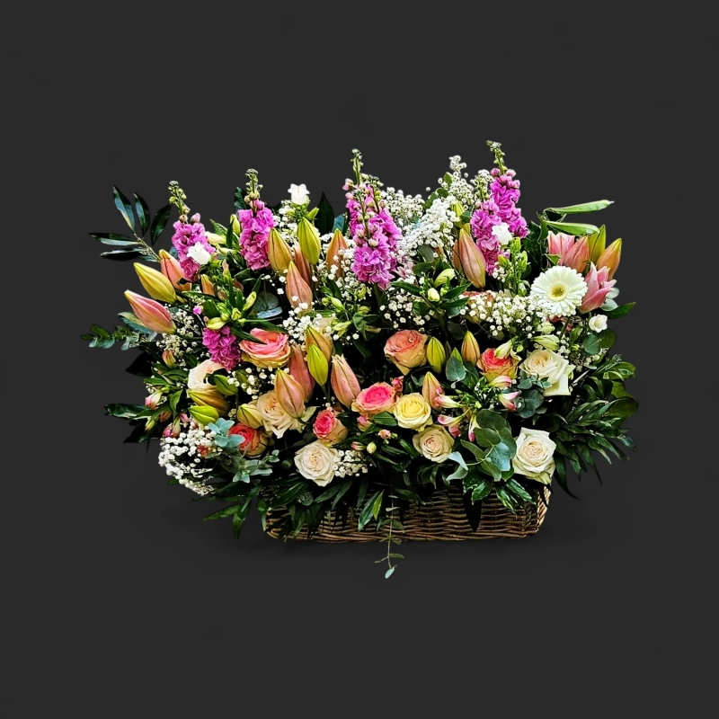 Fleurs deuil Genève : arrangement rectangulaire pastel en osier, roses, lis en boutons et giroflées