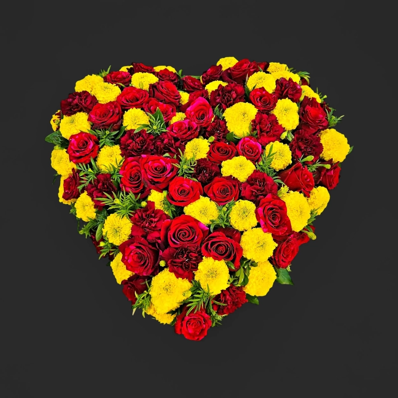 Fleurs deuil Genève : cœur de roses rouges, œillets bordeaux et tagètes posé à plat
