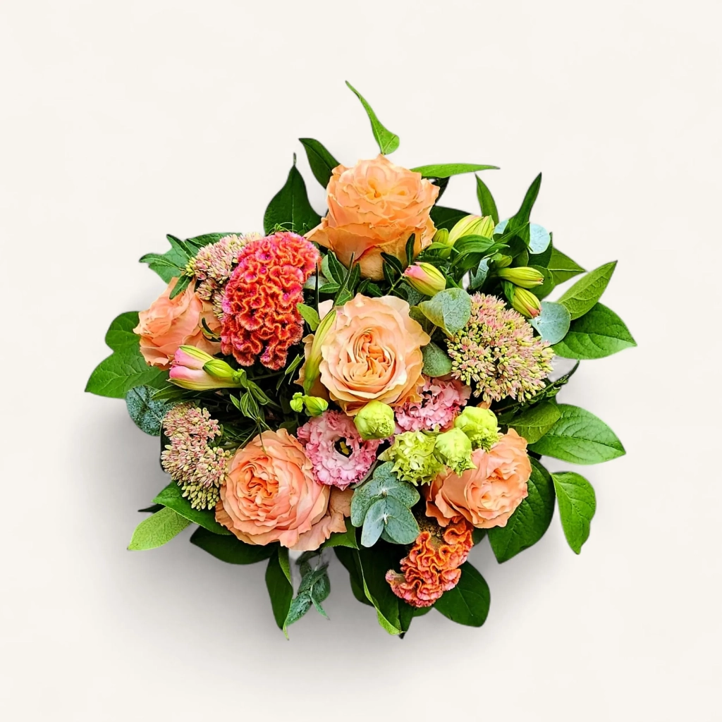 Gros plan sur le bouquet roses pêche genève 'Carnet de Septembre', une harmonie pastel de roses, célosie et sedum.