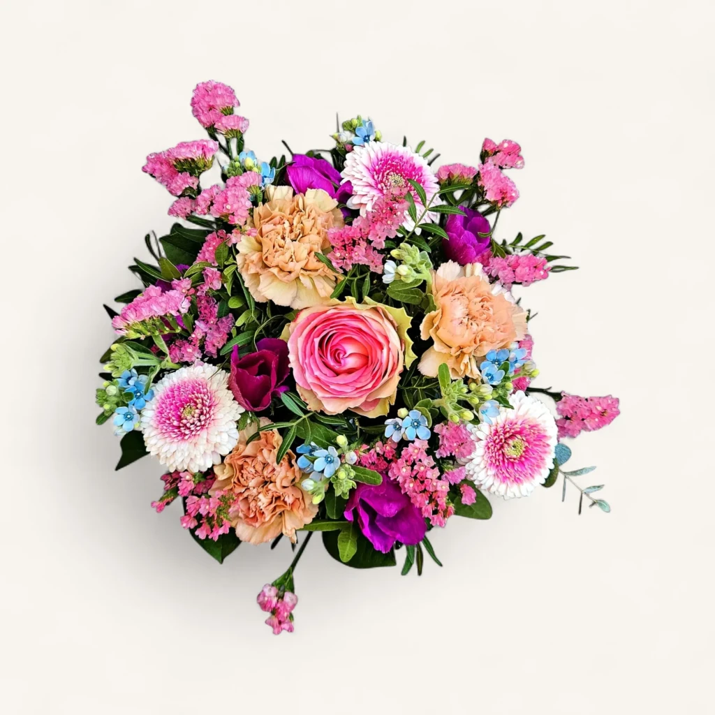Gros plan du Rosée du Portique, notre bouquet printemps Genève, avec sa rose praline, ses œillets pêche et ses myosotis bleus.